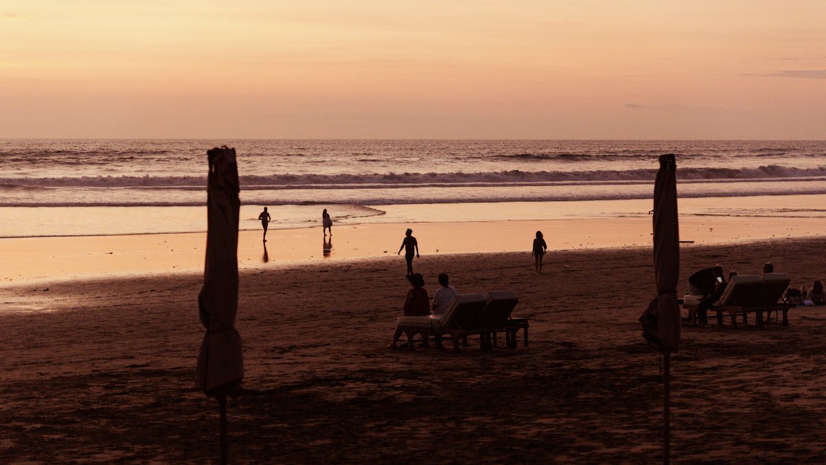 People relaxing on a beach at sunset with golden light