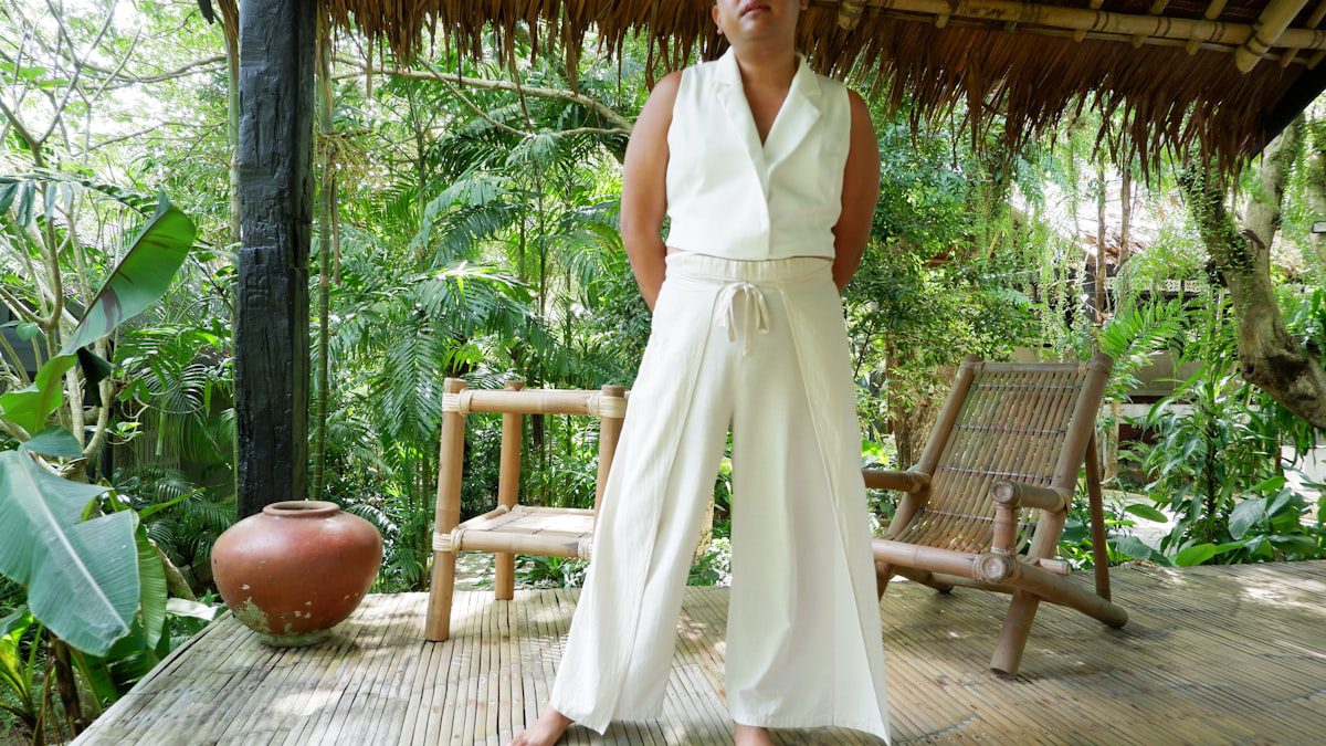 Woman in a white outfit standing on a wooden porch