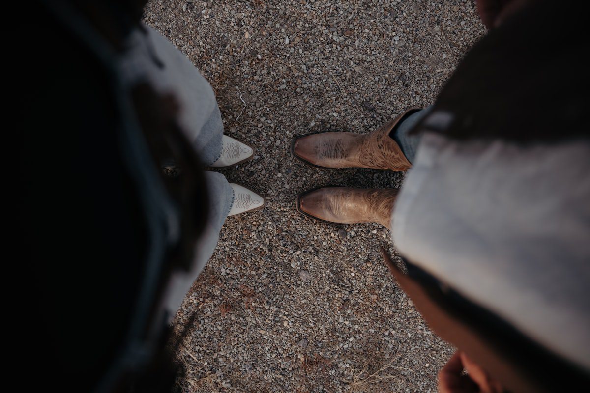 Two people wearing cowboy boots outdoors