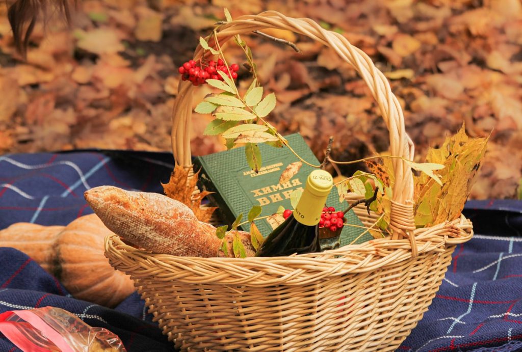 A wicker basket filled with wine and artisan bread