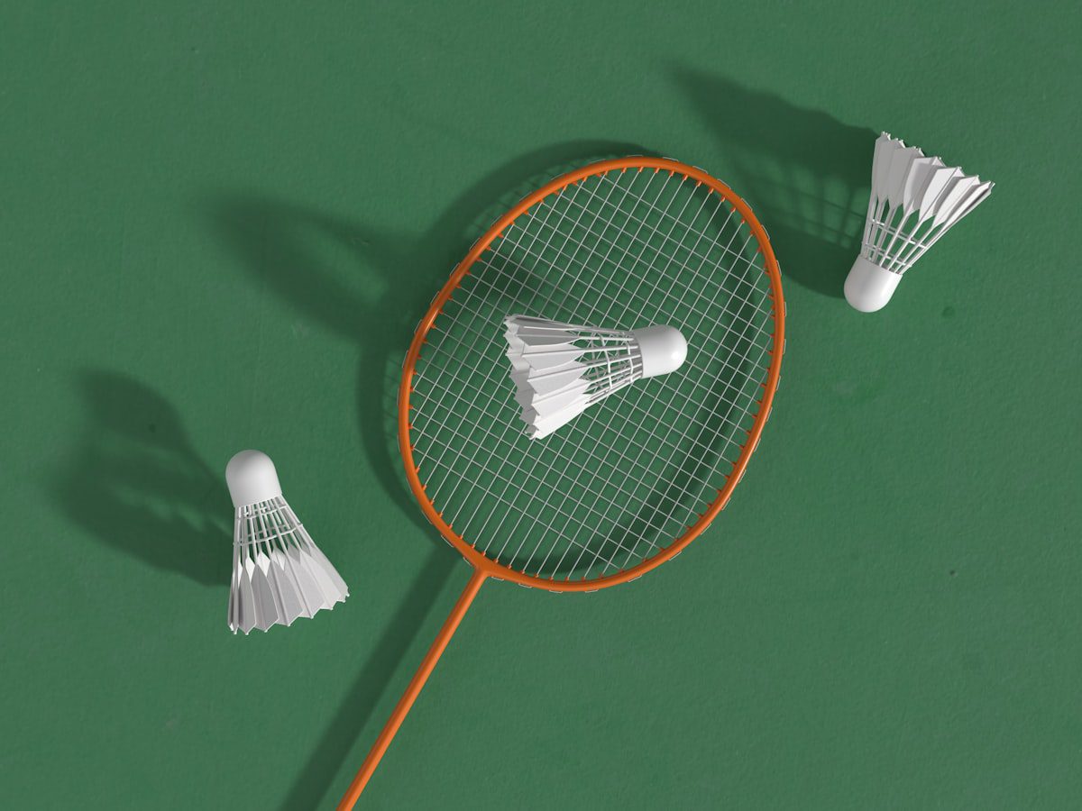 A badminton racket and shuttlecocks on a green court