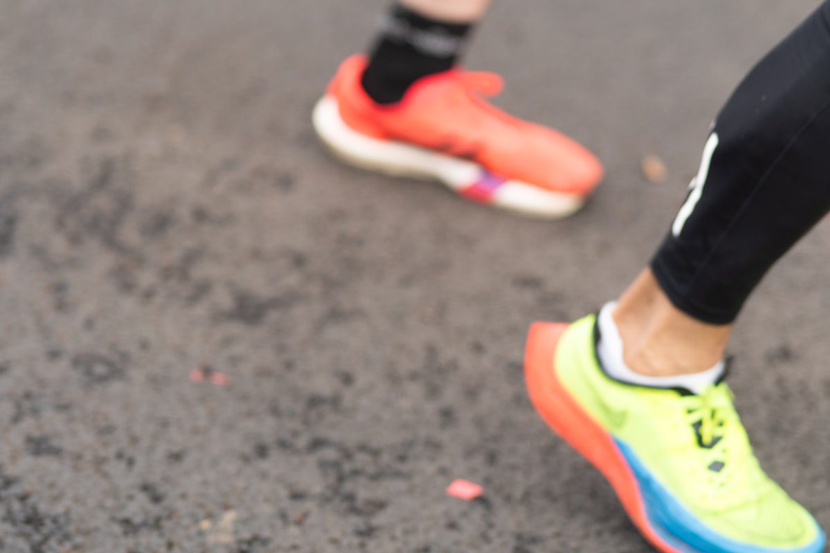Runners feet in colorful athletic shoes on pavement