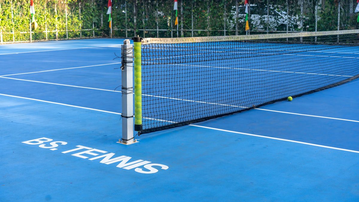 Blue tennis court with net and ball