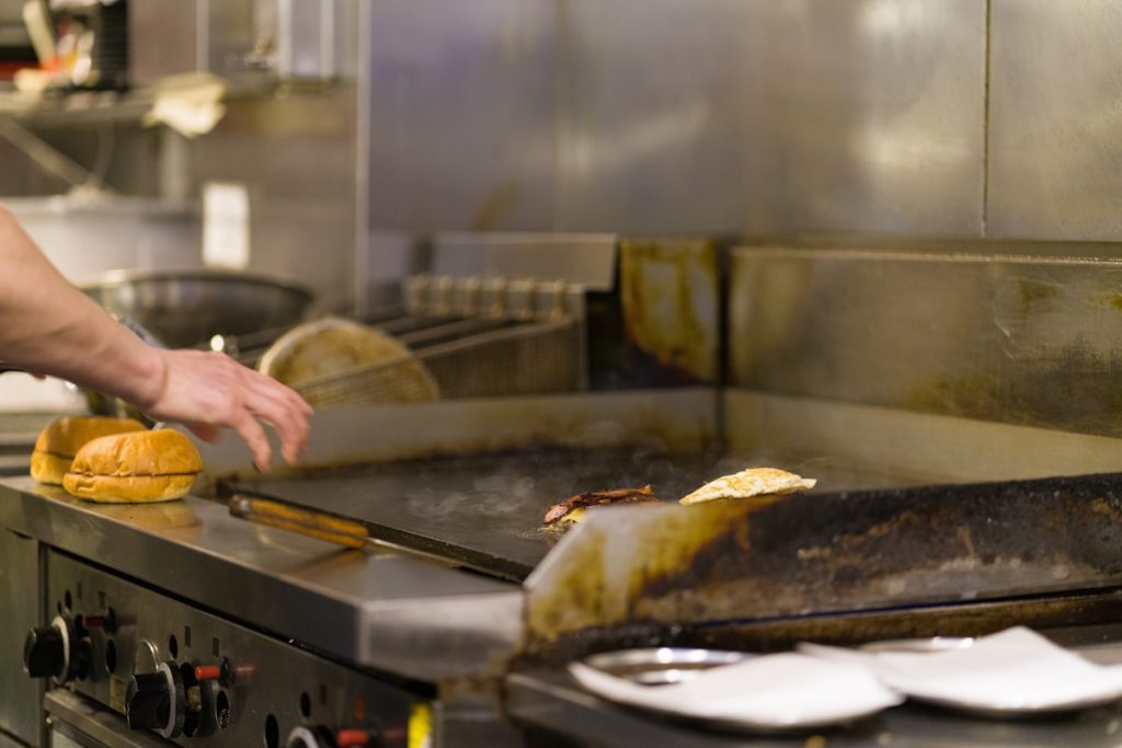 Chef preparing food on a commercial grill