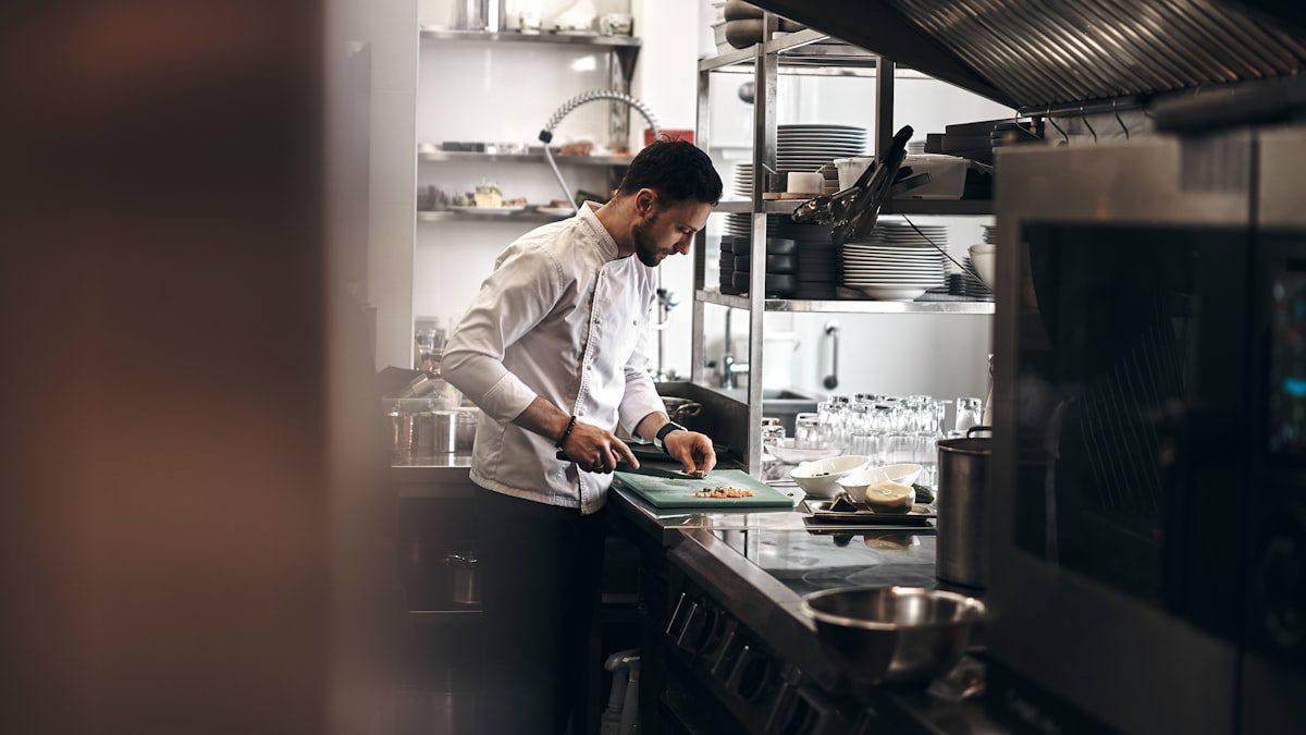 Professional chef plating a dish in a restaurant kitchen