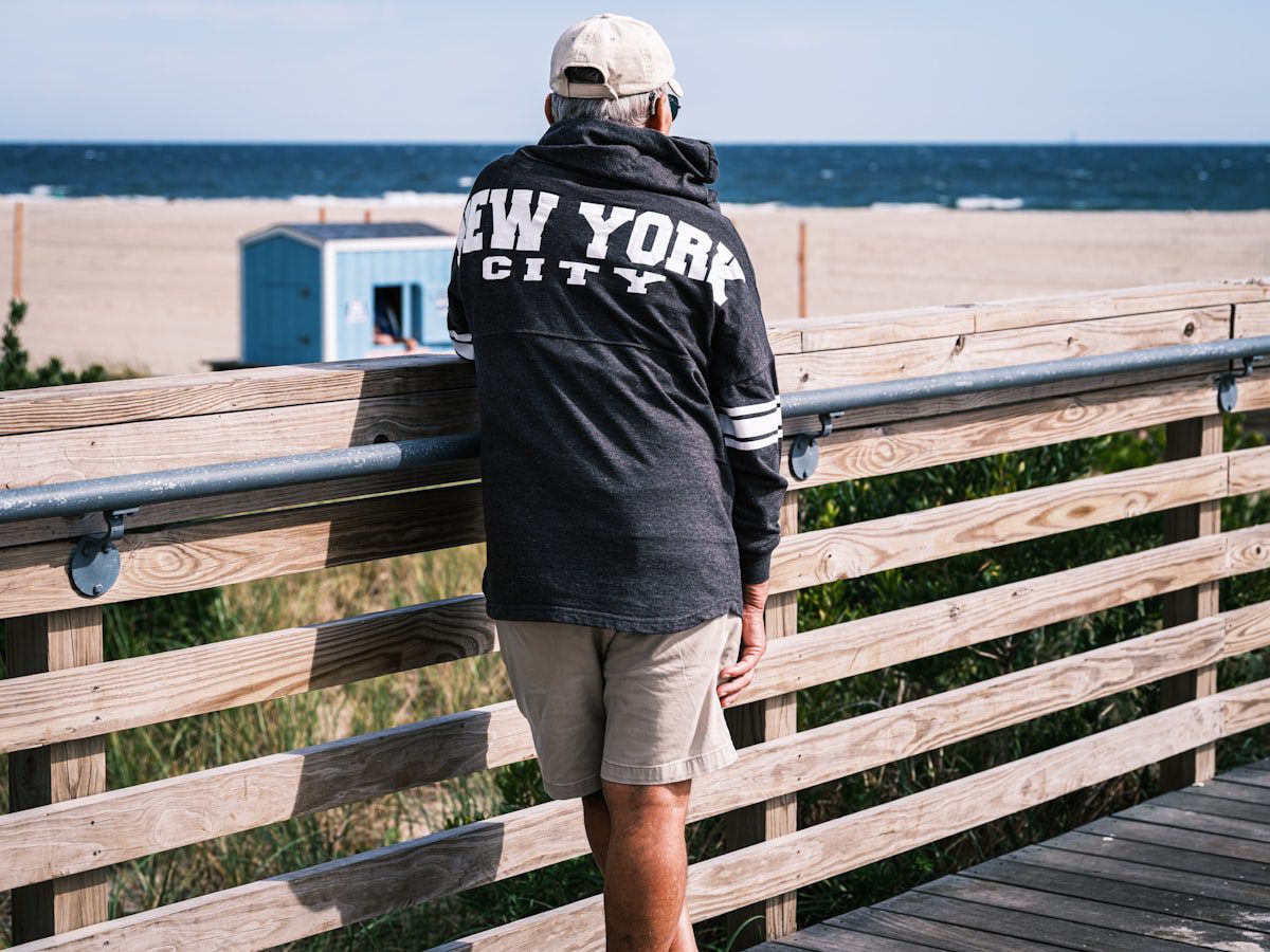Person in new york city jacket looking at the ocean.