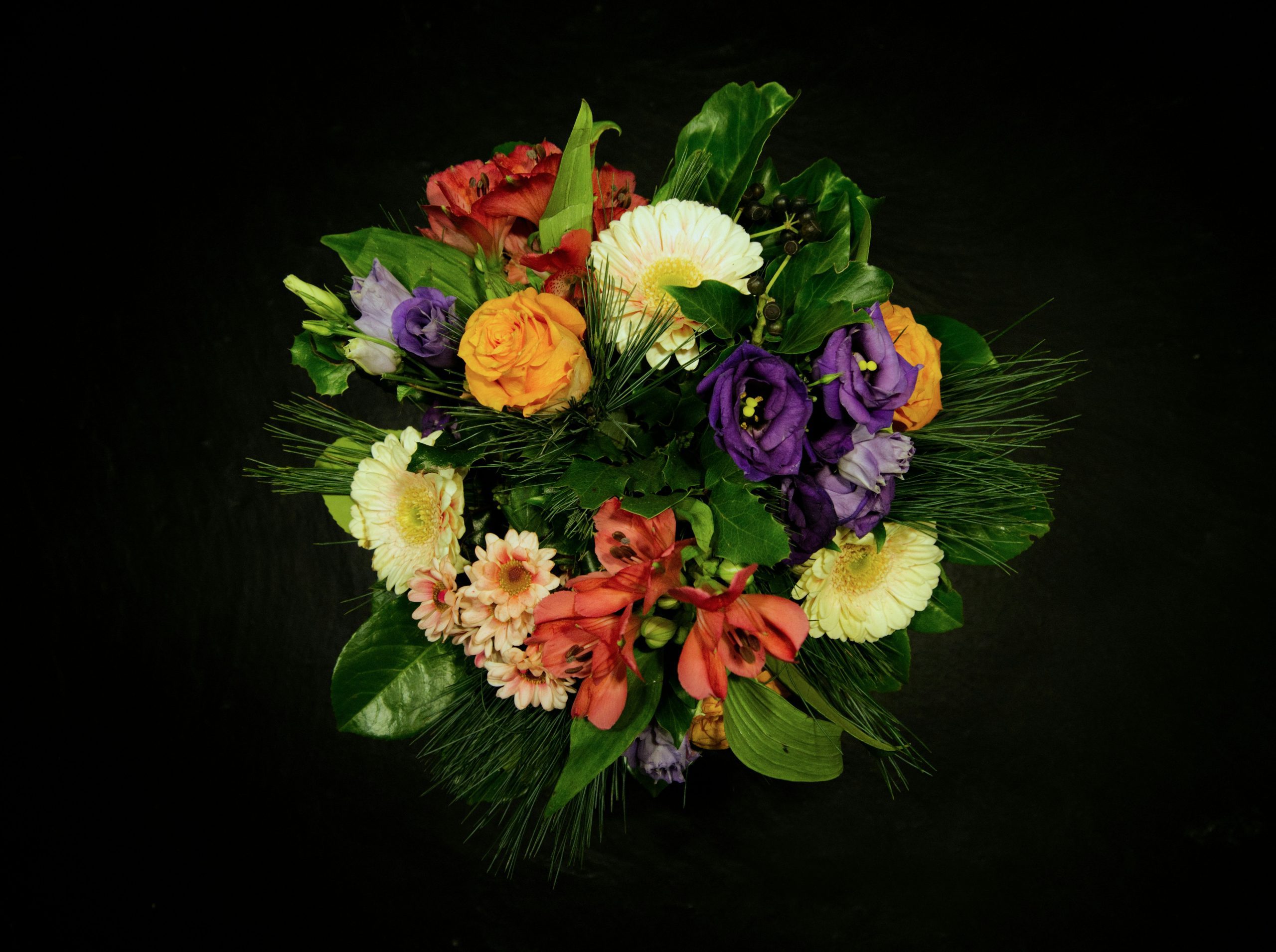 Colorful mixed flower bouquet with orange roses, purple lisianthus, and white gerberas