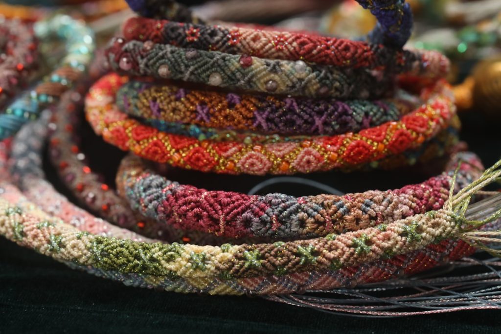 Colorful woven bracelets stacked together at an artisan market