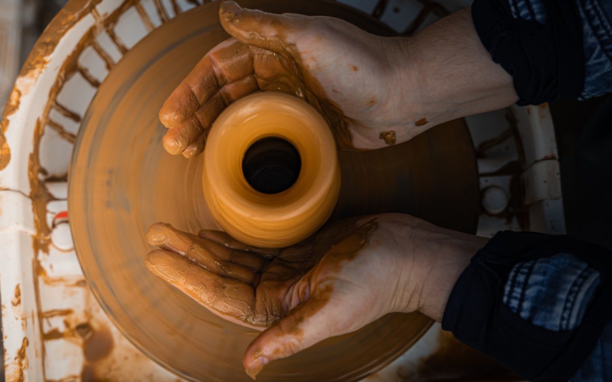 Potter shaping clay on a spinning wheel in an artisan workshop