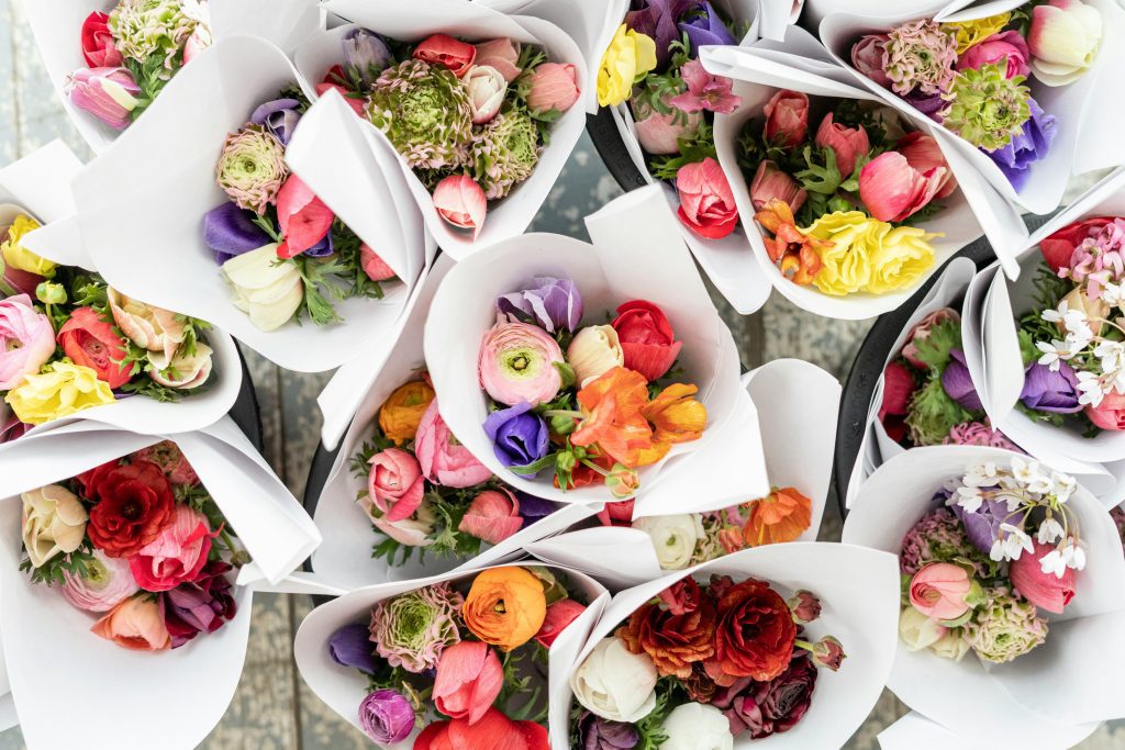 Colorful flower bouquets wrapped in white paper at a flower market